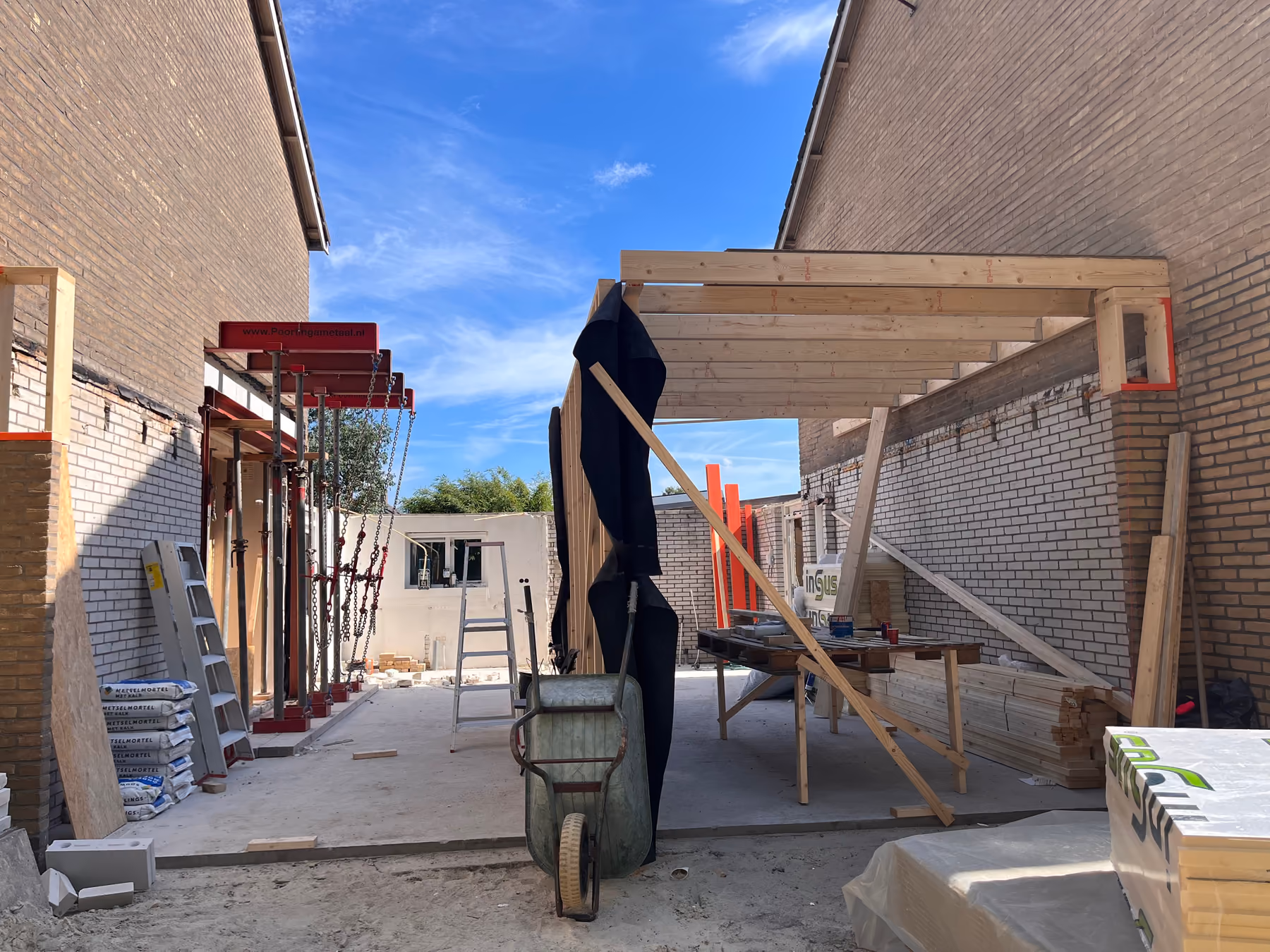 Houten dakconstructie van de nieuwe aanbouw tussen twee woningen, dak nog open