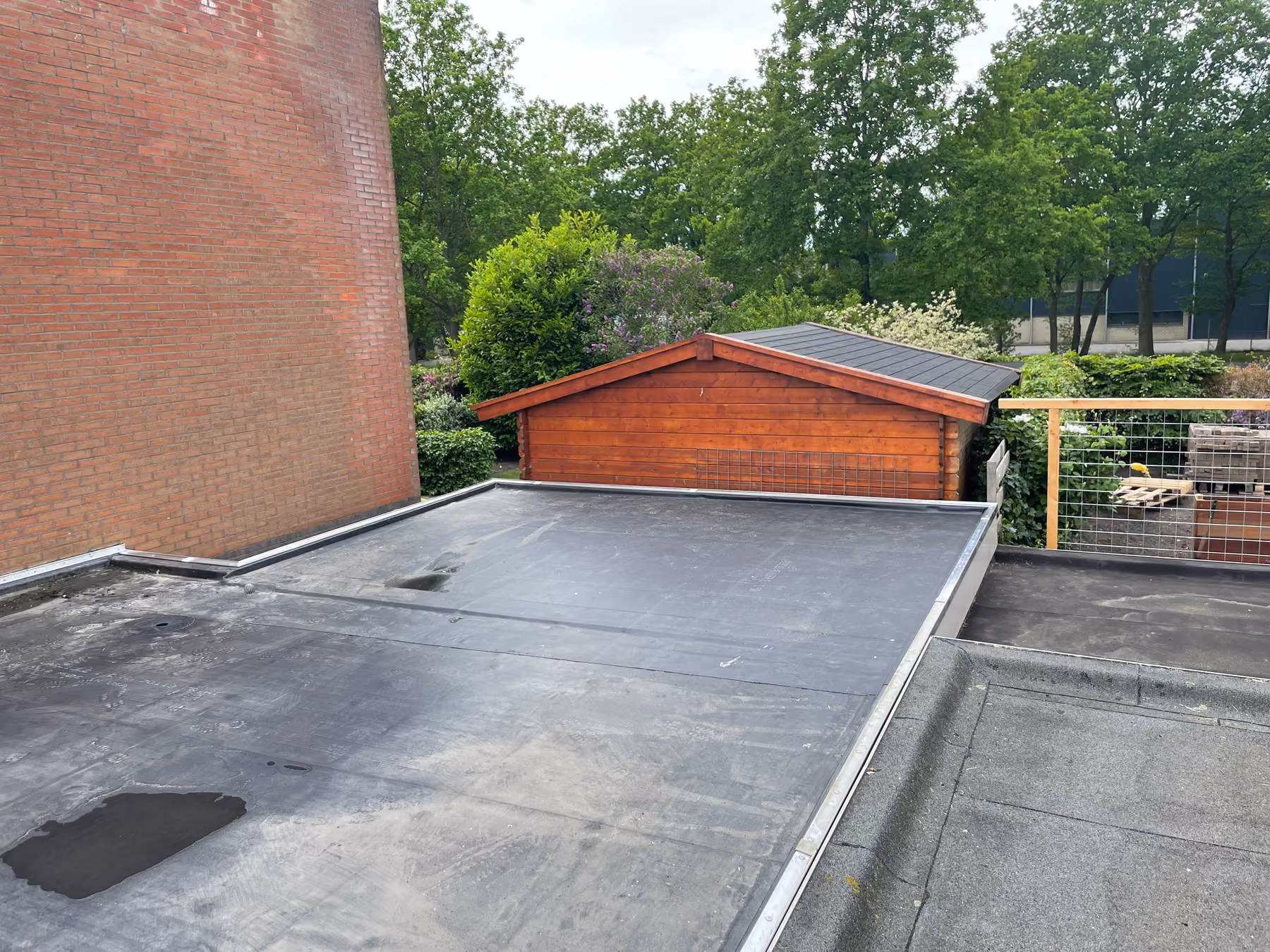 Plat garagedak met zwarte EPDM-dakbedekking en aluminium daktrim langs de randen