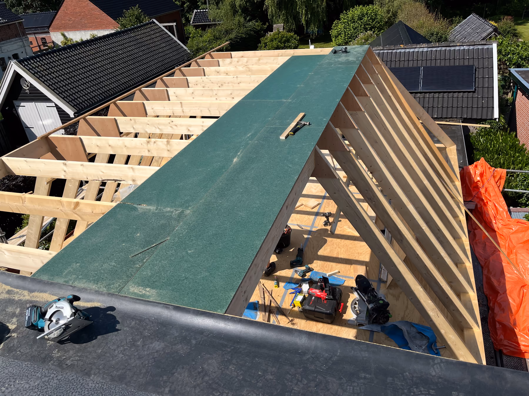 Kapconstructie met houten sporen en groene dakbeschotplaten, gezien van bovenaf