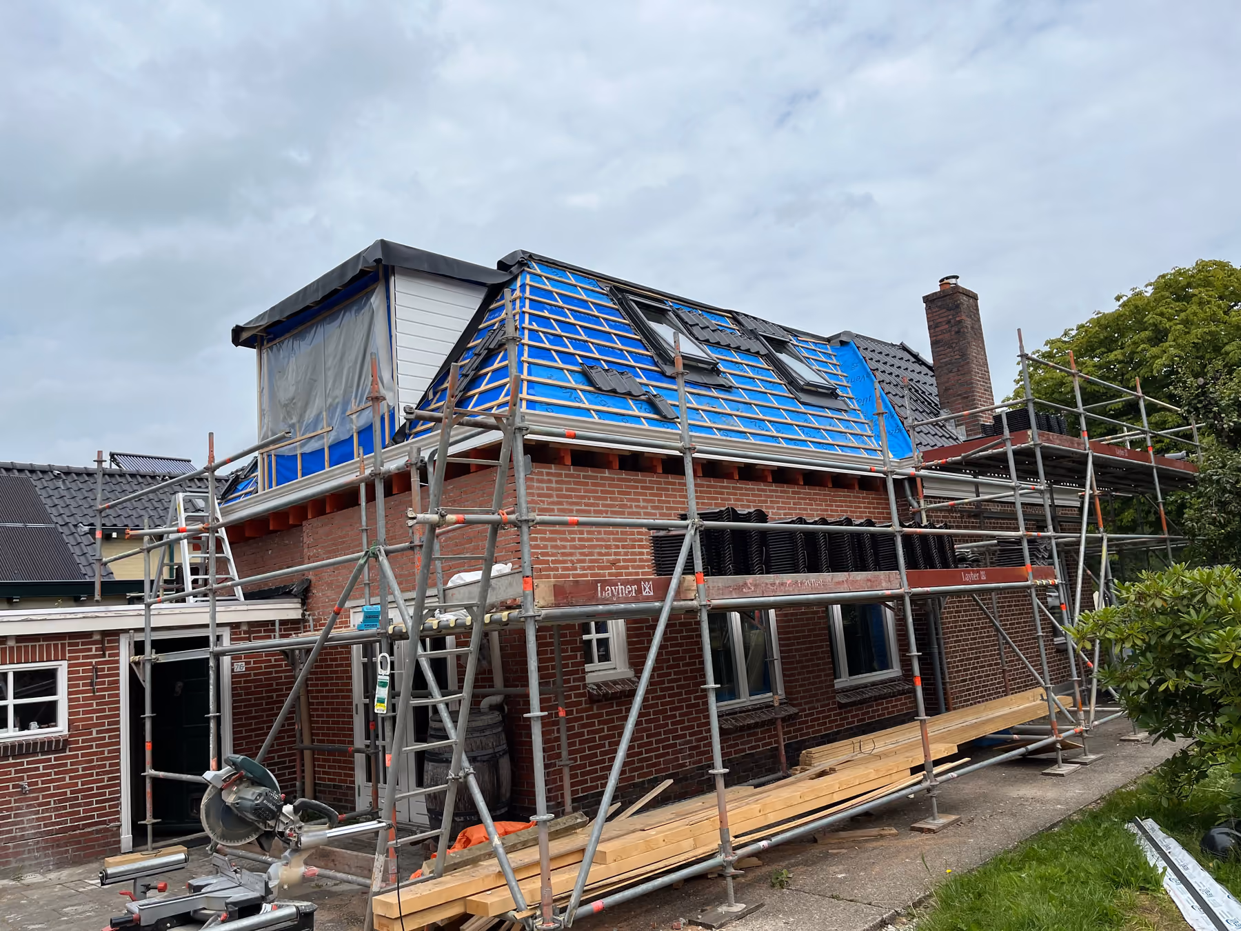 Overzicht van woning met steiger, nieuwe dakkapel en dakvlak in aanbouw