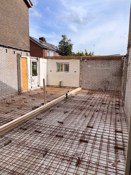 Wapeningsnet en leidingdoorvoeren op de vloer van de nieuwe aanbouw