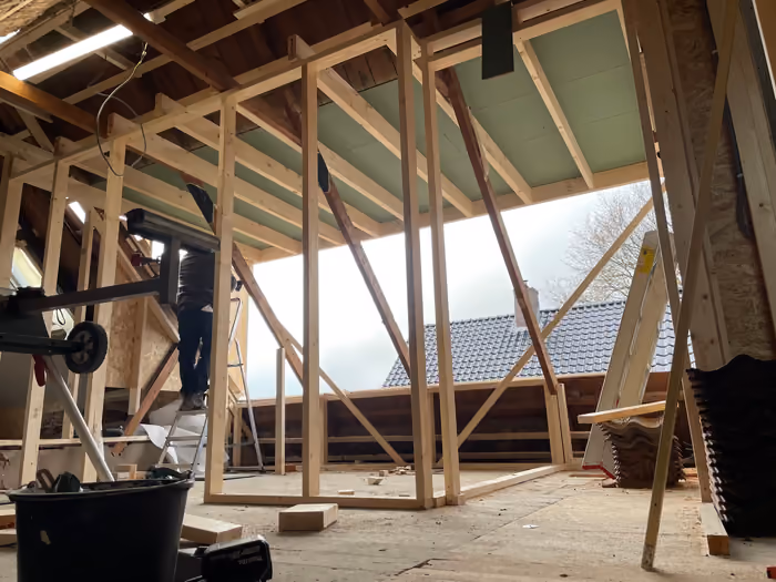 Zolder met houten frame voor een brede dakkapel, dakvlak geopend