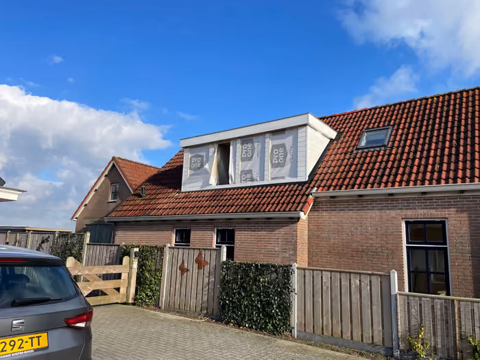 Nieuwe dakkapel met witte zijwangen, ramen nog afgedekt met beschermfolie