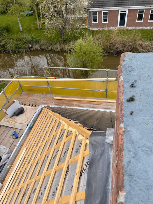 Uitzicht vanaf de schoorsteen over dakconstructie met isolatie en steiger