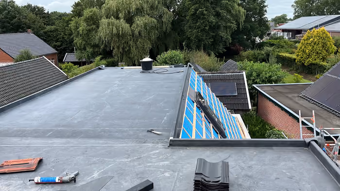 Afgewerkt plat dak met daarnaast een schuin dakvlak in blauwe folie