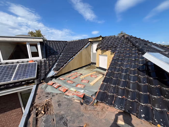 Pannendaken met dakkapel, zonnepanelen en de houten wanden van een dakterras