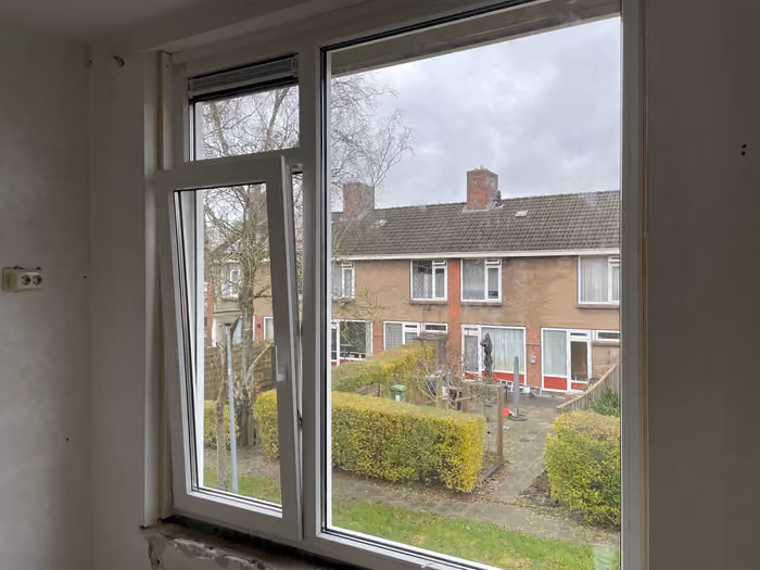 Nieuw kunststof kozijn met draaikiepraam gezien vanuit een kale kamer