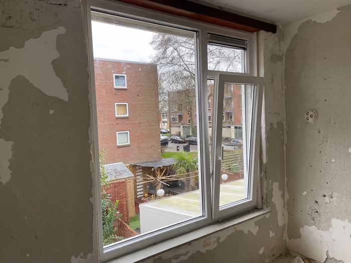 Geplaatst kunststof kozijn in een kamer met kaalgehaalde, gestripte muren