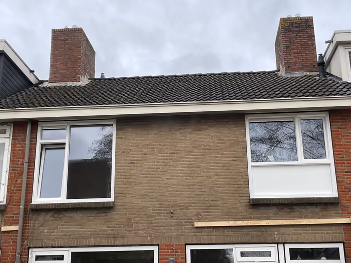 Achtergevel met nieuwe witte kozijnen op de bovenverdieping van twee woningen
