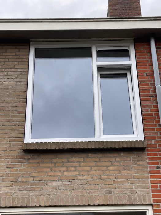 Nieuw wit kozijn met groot vast glas en smal draaideel op de verdieping