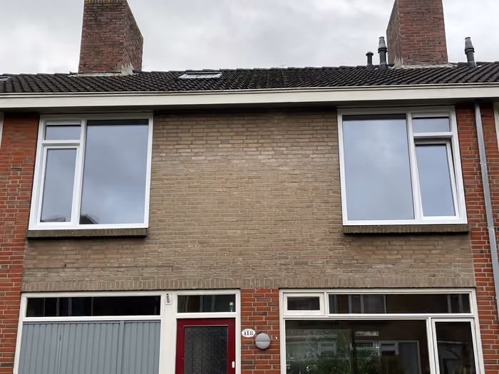 Voorgevel van een rijwoning met nieuwe witte kozijnen op de verdieping