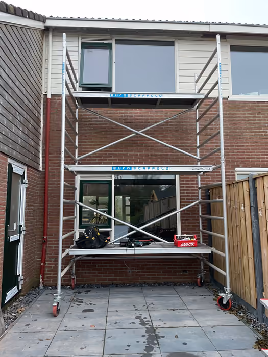 Rolsteiger met gereedschap voor de achtergevel tijdens het vervangen van kozijnen