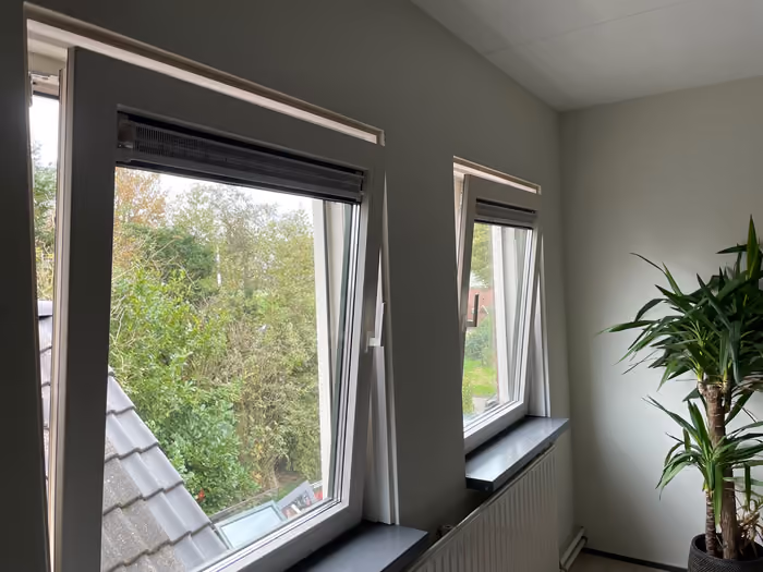 Twee nieuwe kozijnen met draaikiepramen in een lichte kamer met plant