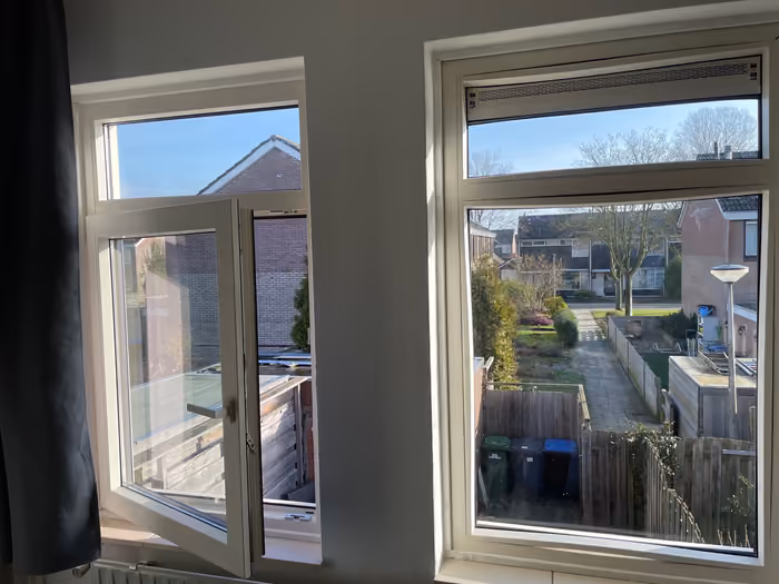 Nieuwe witte kozijnen op de bovenverdieping, één draaikiepraam staat open