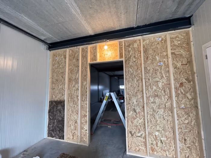 Houten regelwerk met OSB-beplating en isolatie, doorgang naar de volgende ruimte