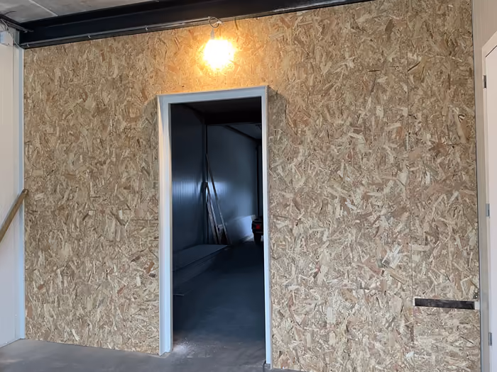 Met OSB beplate scheidingswand met deuropening in een bedrijfsruimte