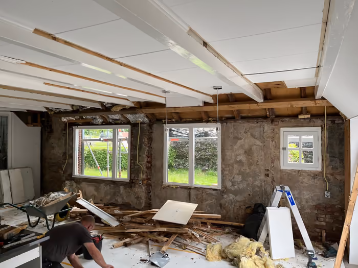 Kamer met nieuw wit plafond en kozijnen, sloophout op de vloer