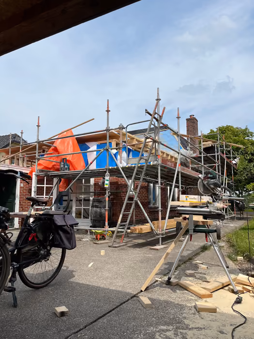 Woning met steiger en nieuwe dakconstructie, gezien vanaf een overkapping
