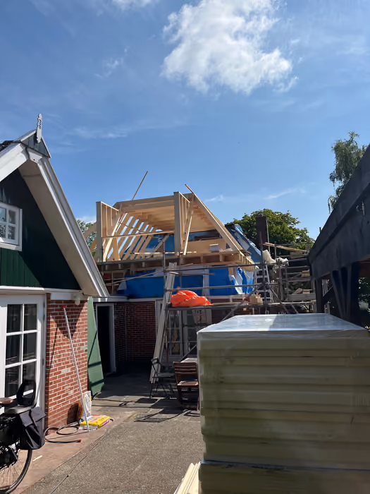 Nieuwe kapconstructie in aanbouw met een pallet isolatieplaten op de voorgrond