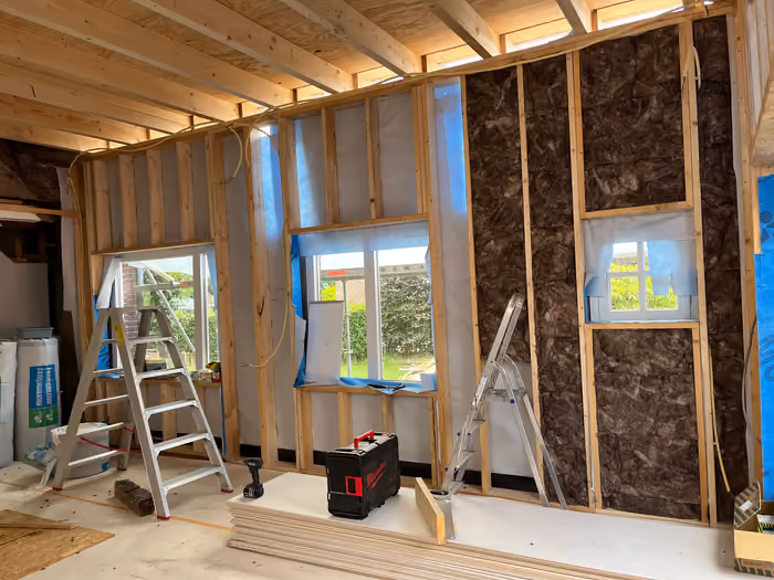 Binnenwand met houten regelwerk, isolatie en nieuwe raamopeningen tijdens verbouwing