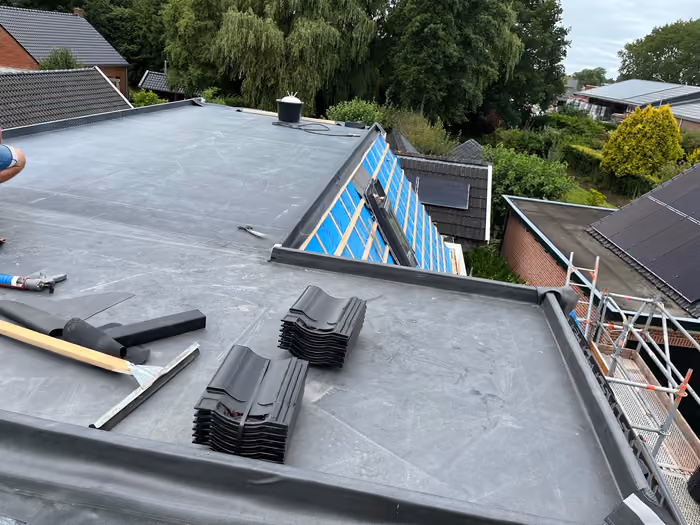 Plat dak met stapels dakpannen en schuin dakvlak met panlatten