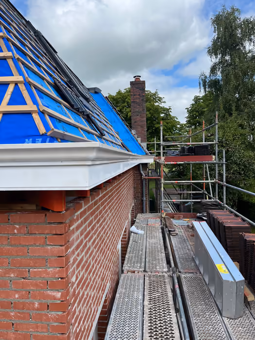 Dakrand met nieuwe goot, panlatten op folie en twee dakramen