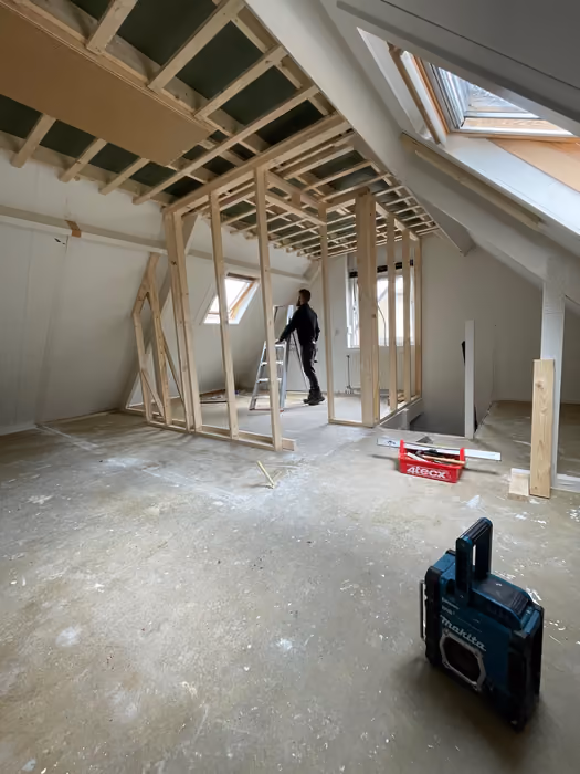 Nieuw houten stijl- en regelwerk voor zolderwanden, timmerman aan het werk